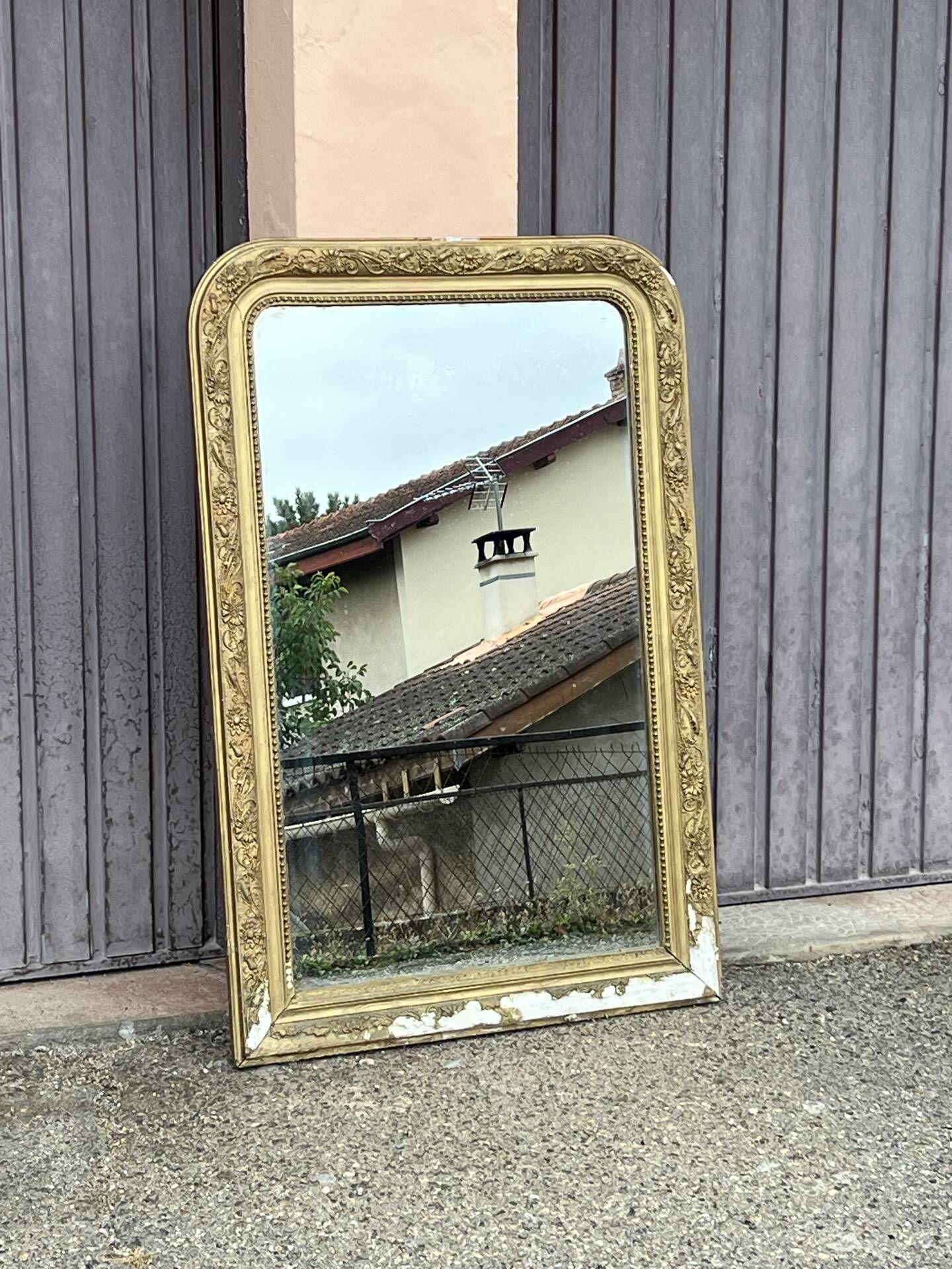 Large Louis Philippe mirror in carved gilded wood with mercury glass.
