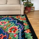 Rug with floral design on a blue background made by hand in Romania