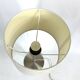 Large brushed metal table lamp with an ecru shade.
