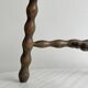Three-legged demi-lune stool made of turned wood