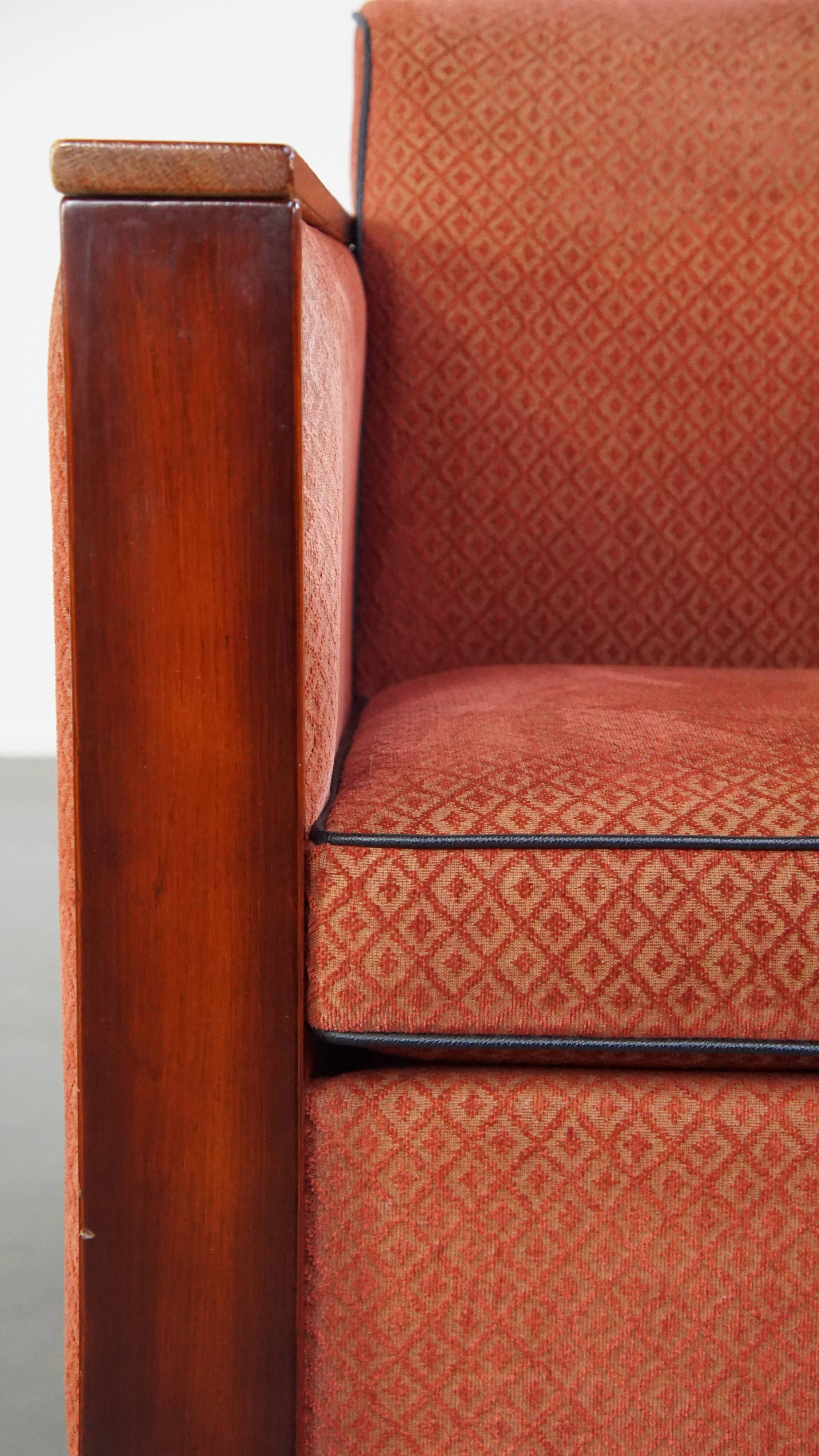 Art Deco design armchair with red fabric upholstery and wooden details