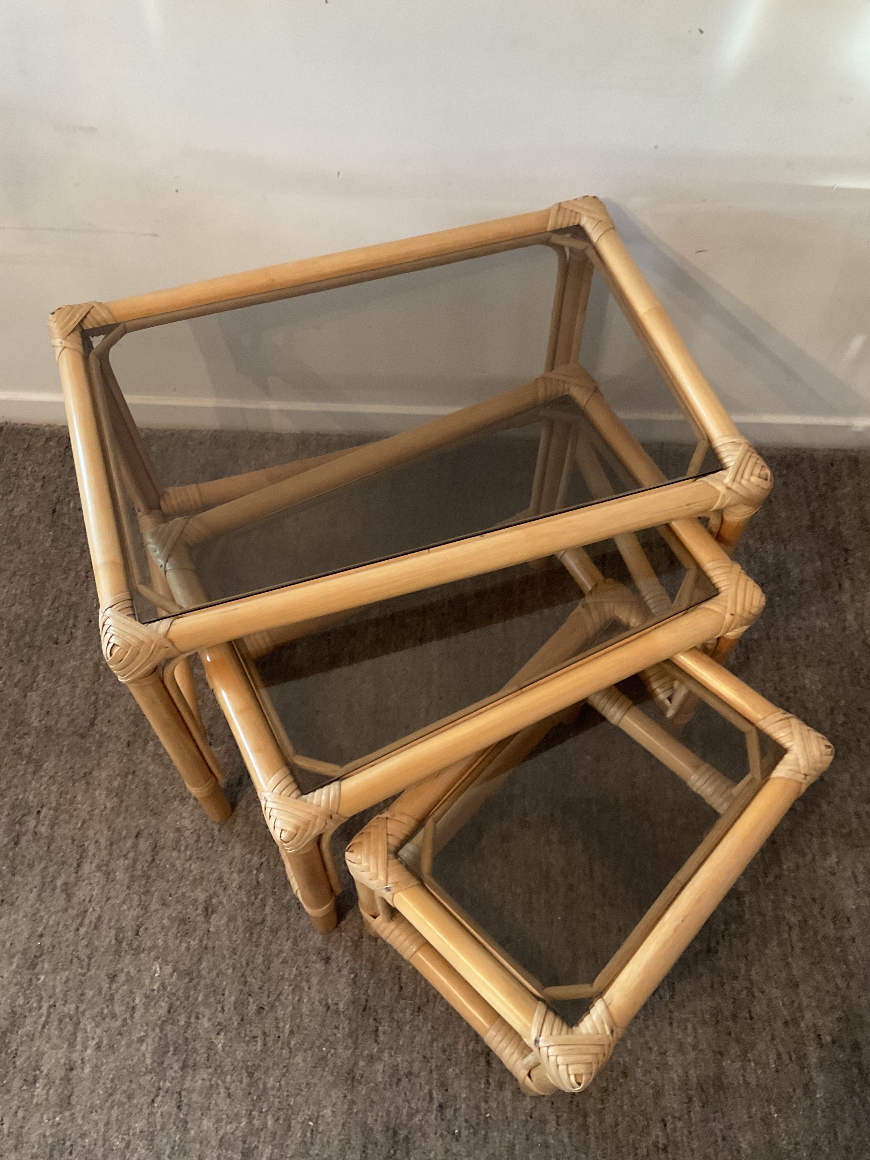 Trio of vintage pull-out tables in rattan and smoked glass 70s