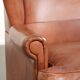 Light cognac-coloured cow leather wingback armchair with matching piping