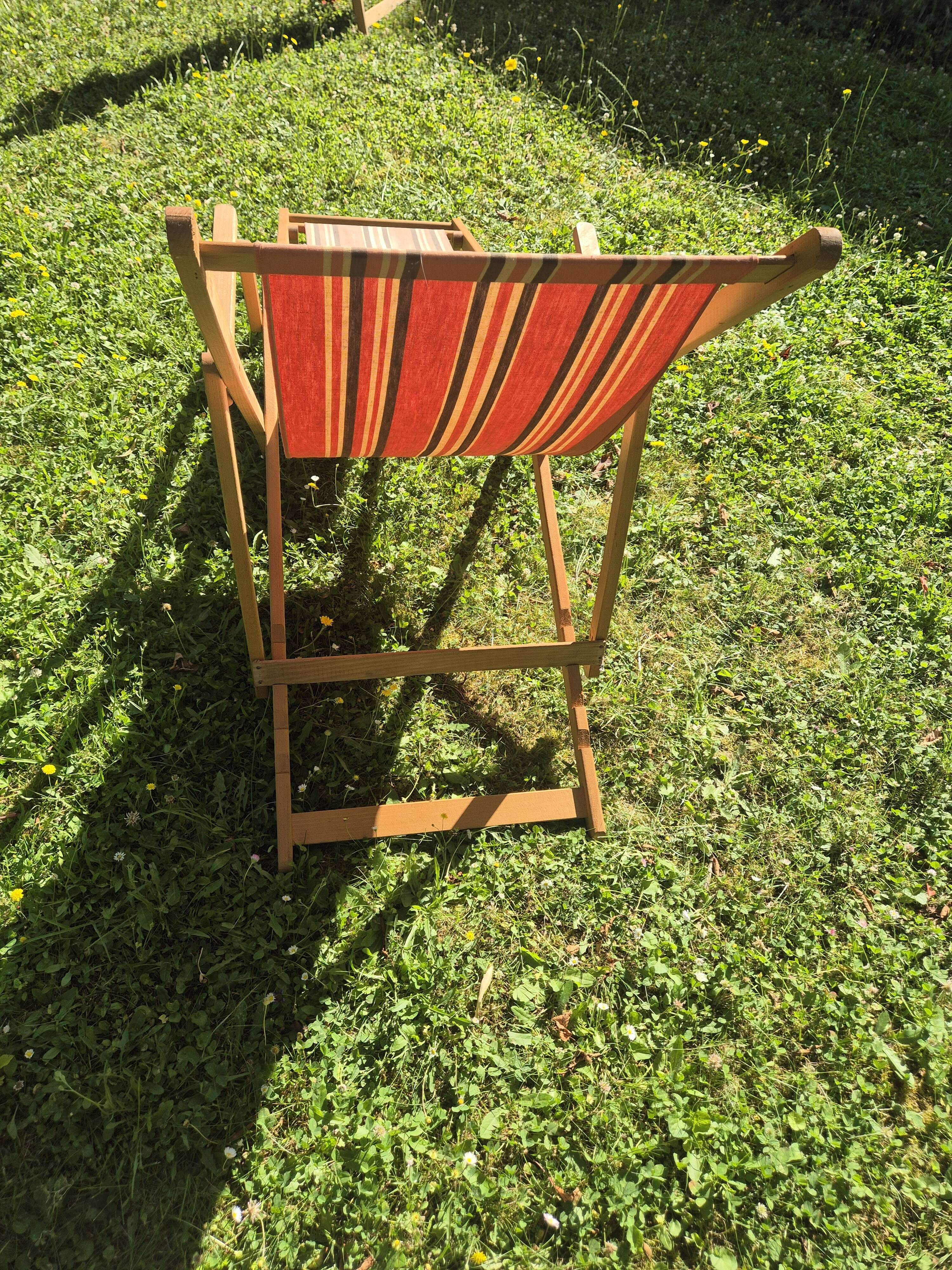 vintage wooden deck chair with striped fabric and footrest