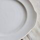 Vintage round white porcelain serving dish with handles.
