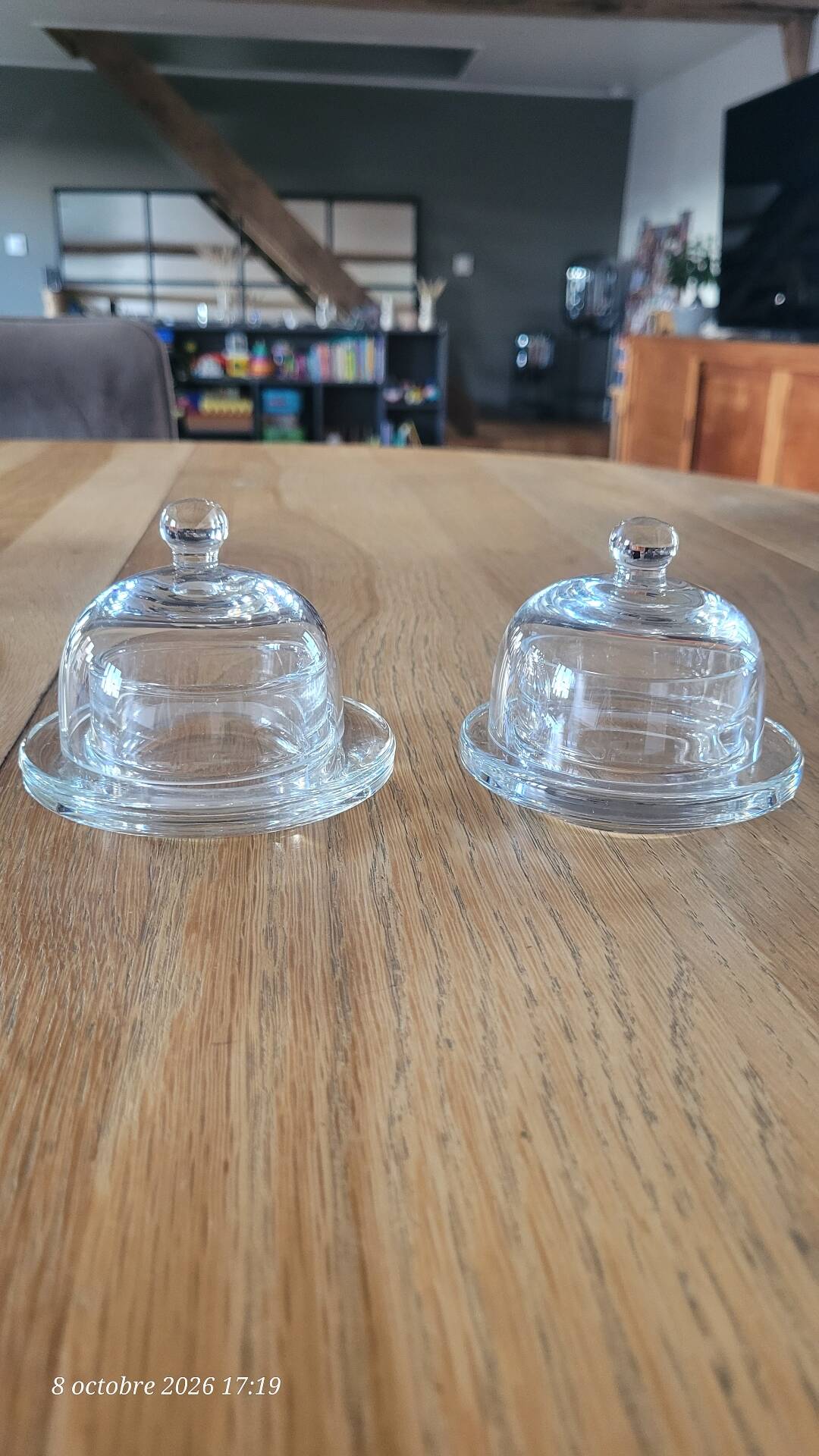 2 transparent glass butter dishes with their matching cloches.