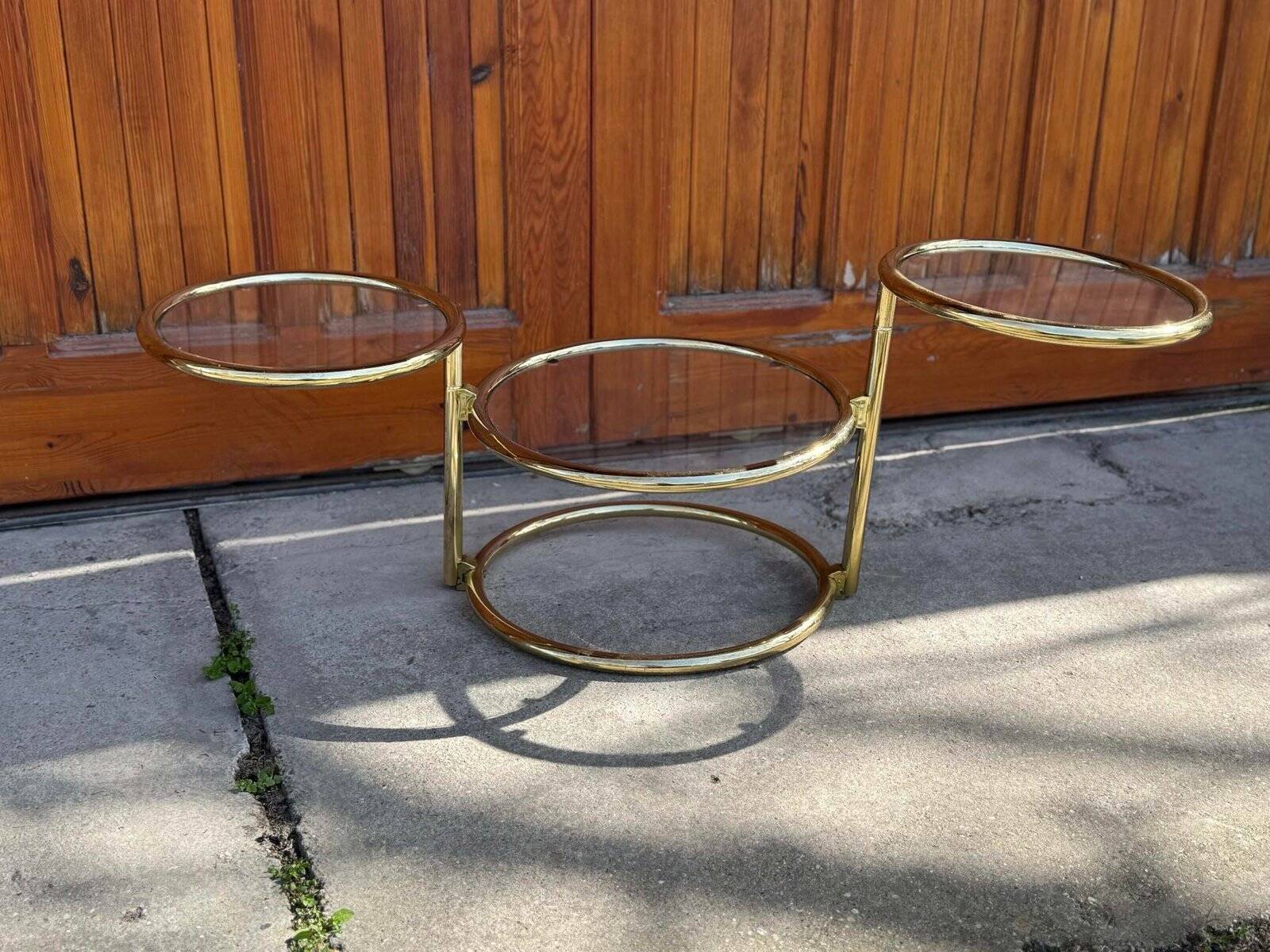 1970s swivel coffee table in gilded brass and glass, Milo Baughman style, vintage design.
