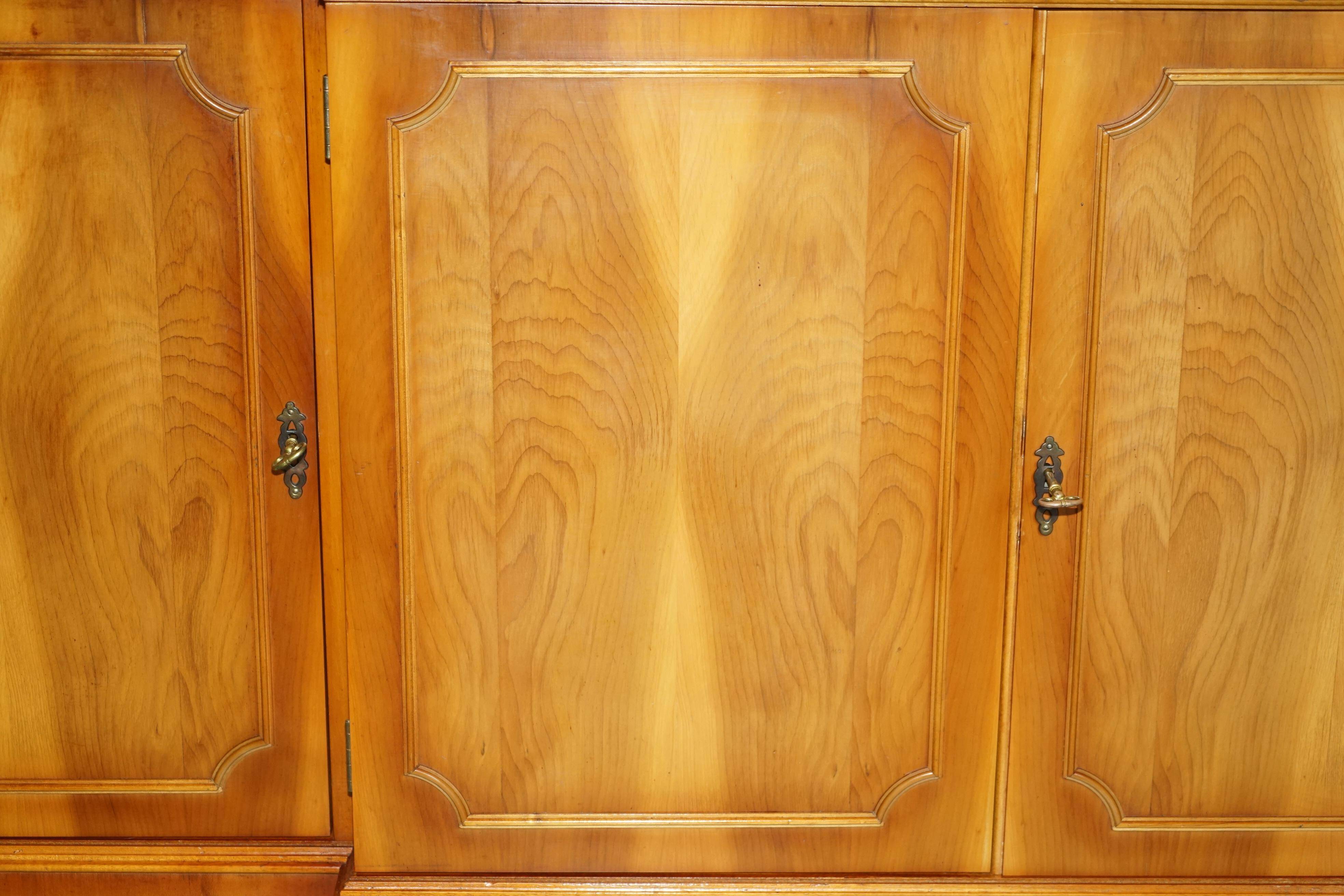 Vintage buffet made of mottled yew wood with three doors and four drawers.