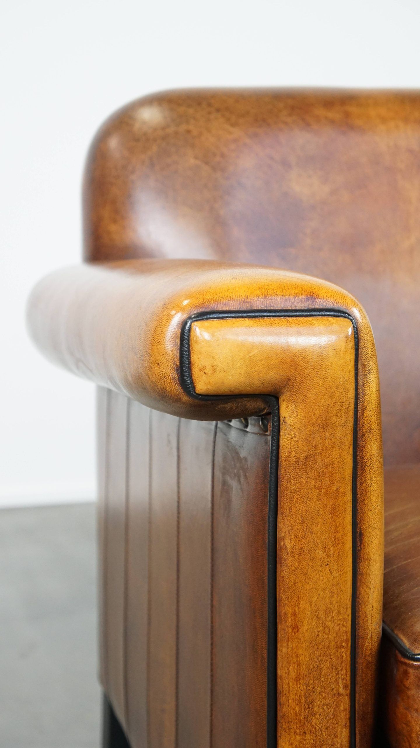 Sheepskin Art Deco design armchair with sleek finish and black piping