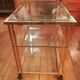 Trolley on wheels in gilded brass and beveled glass