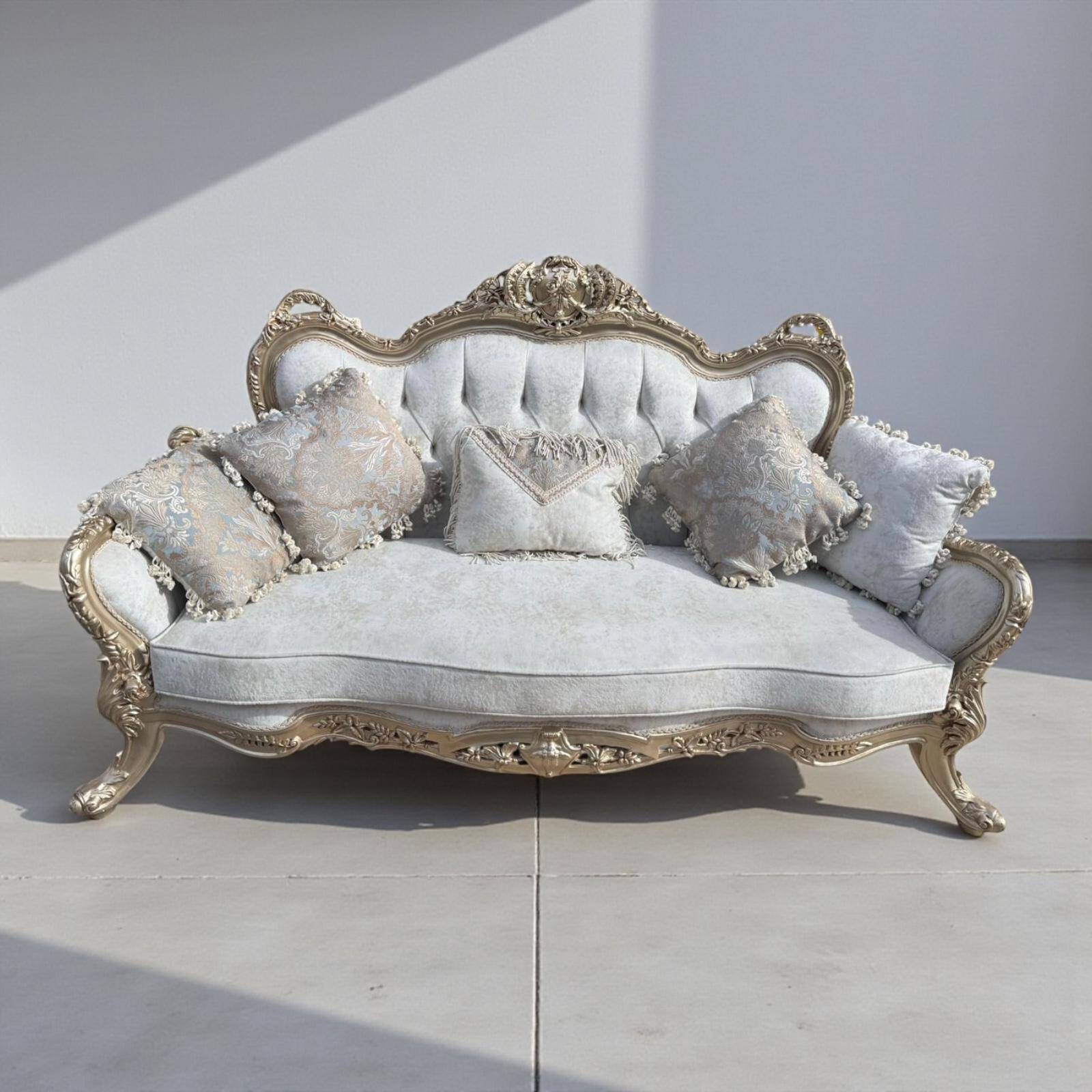 A white and gold tufted beech wood sofa in Louis XV style.