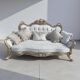 A white and gold tufted beech wood sofa in Louis XV style.