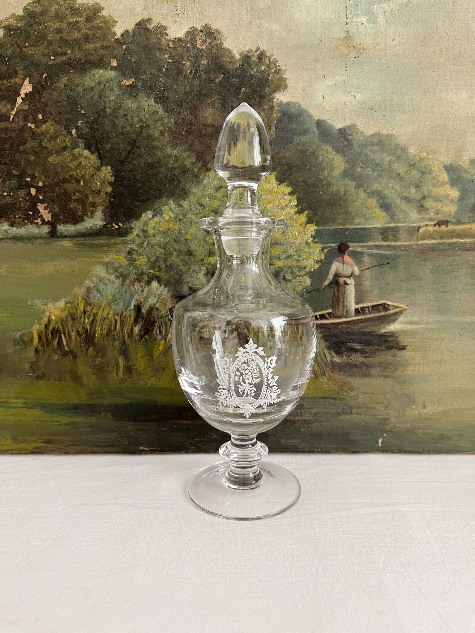 Antique stemmed blown glass bottle with engraved medallion