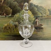 Antique stemmed blown glass bottle with engraved medallion