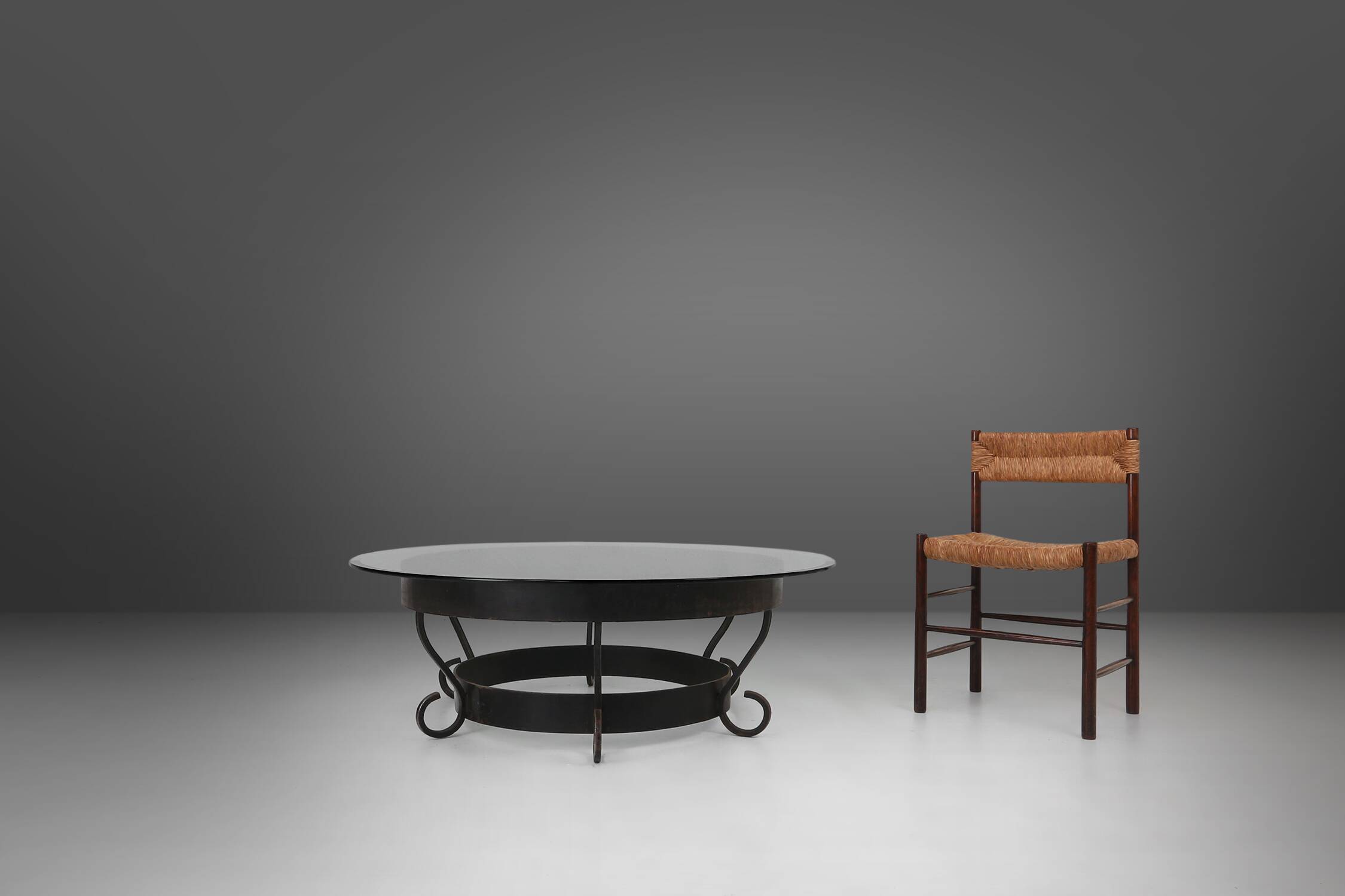 Rustic round coffee table with wrought iron base and glass top, France, 1930s