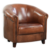 Fauteuil club en peau de mouton vintage de style anglais avec des couleurs profondes.