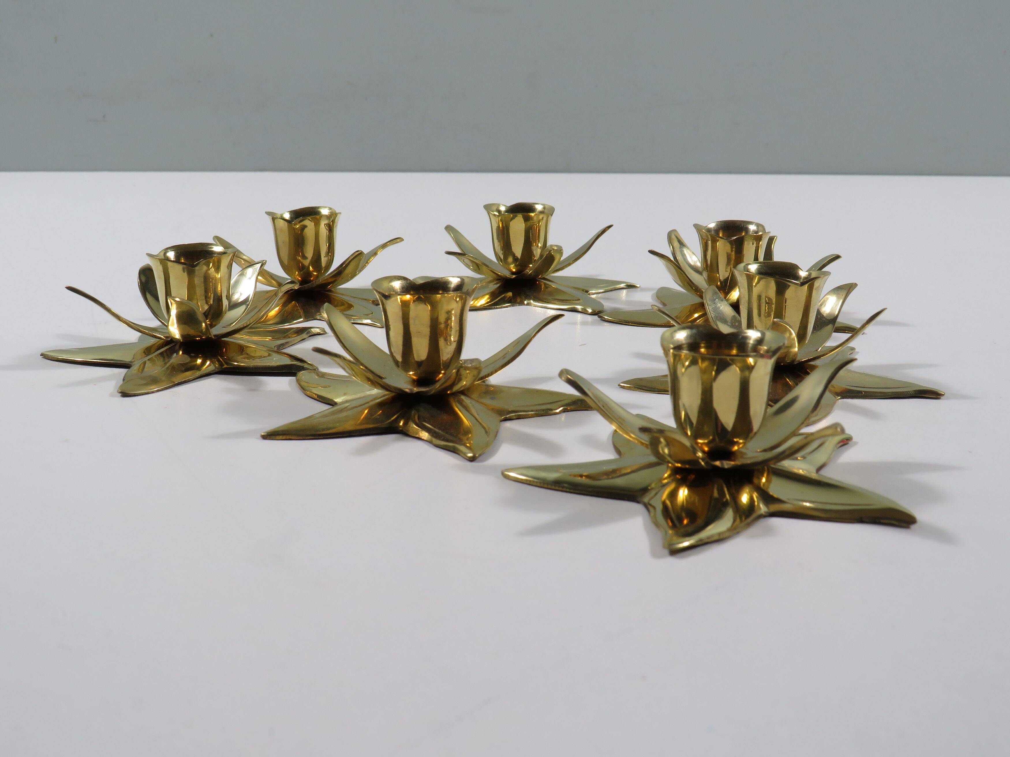 Set of 7 heavy shiny brass flower shaped candle holders, 1970-1980