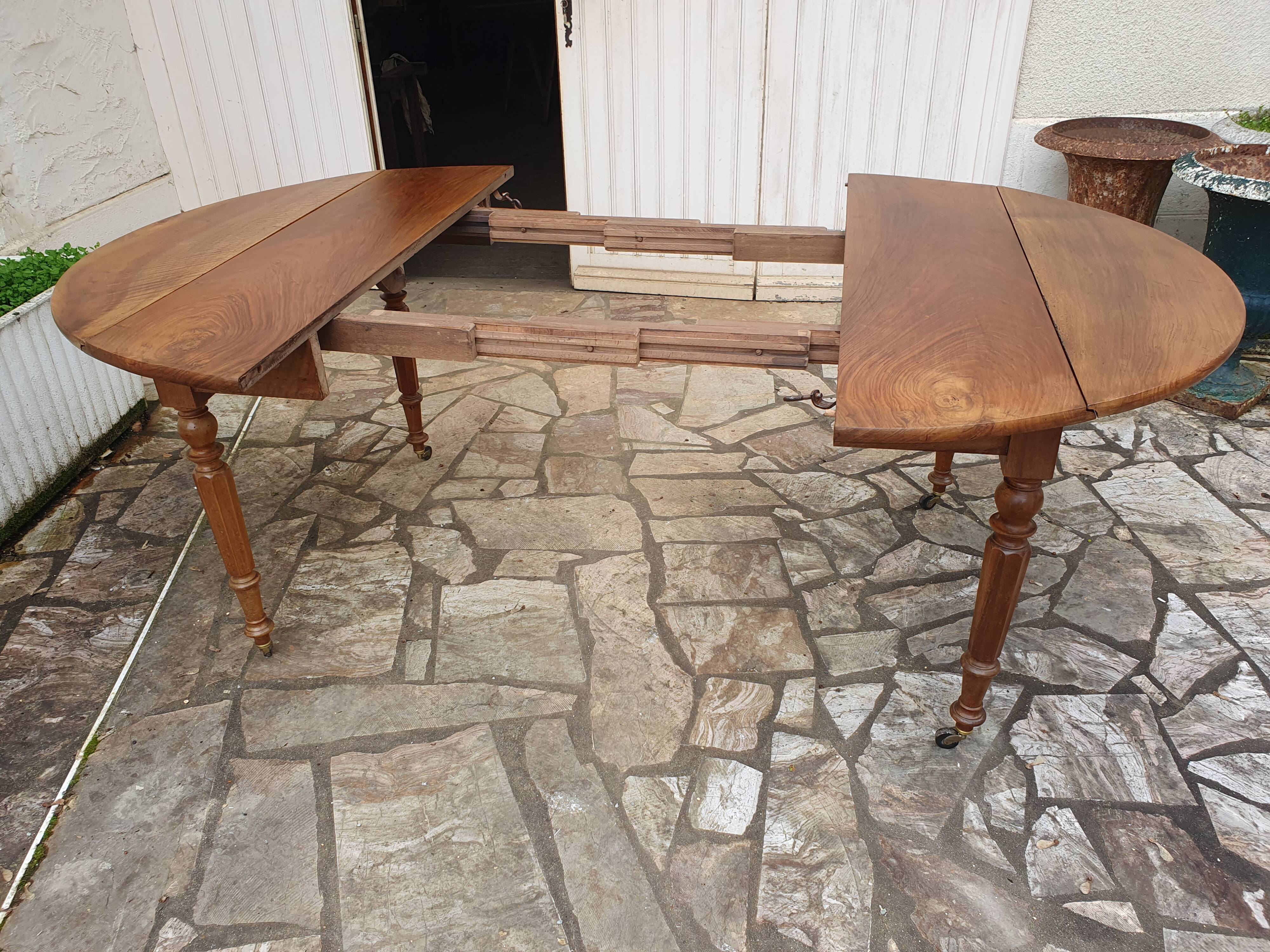 Round extending table in solid walnut, 19th century