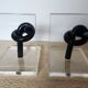 Bookends in plexiglass and knotted black tubes, 1980s design.
