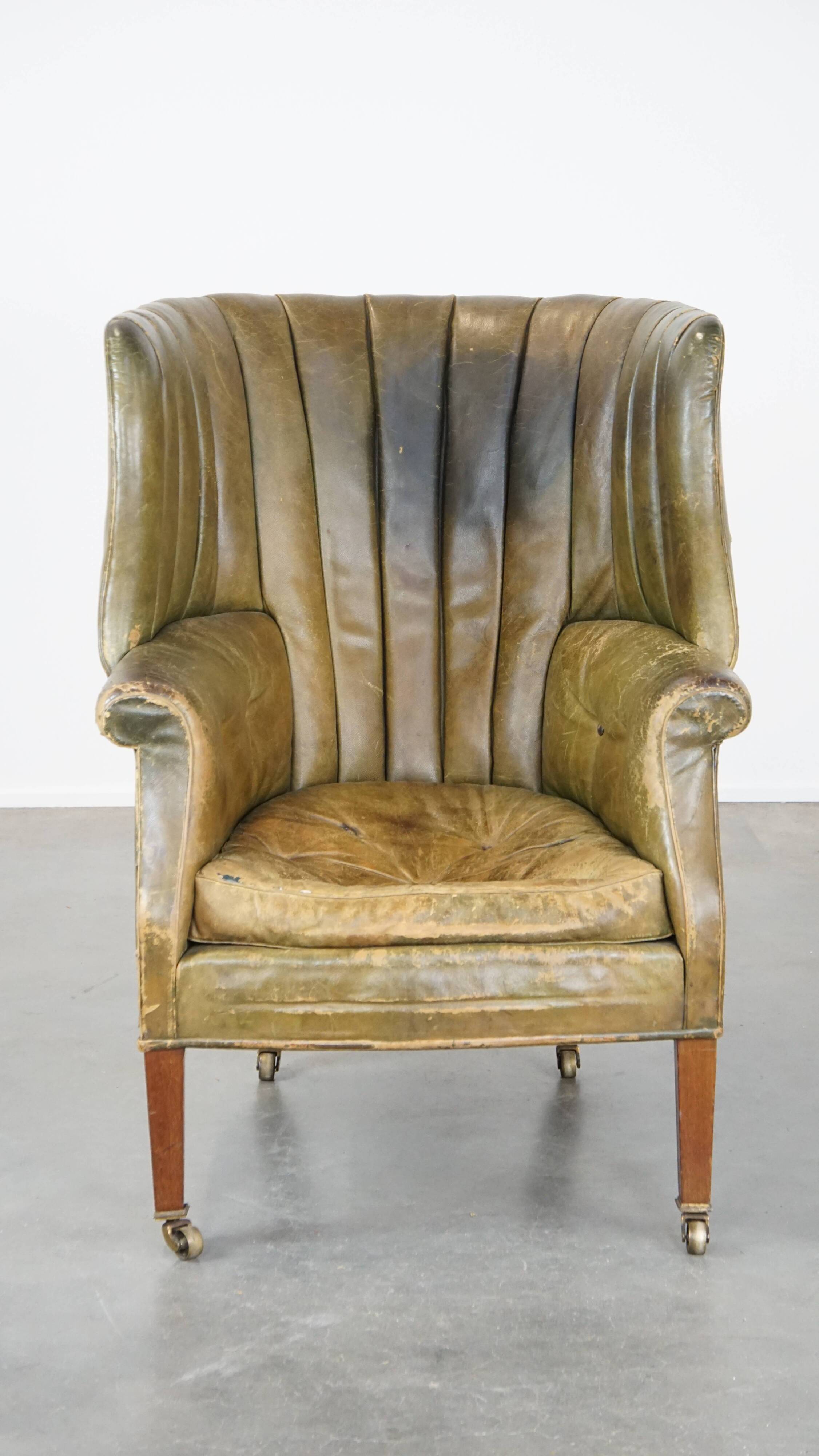 Green antique barrel back wingback chair on wheels