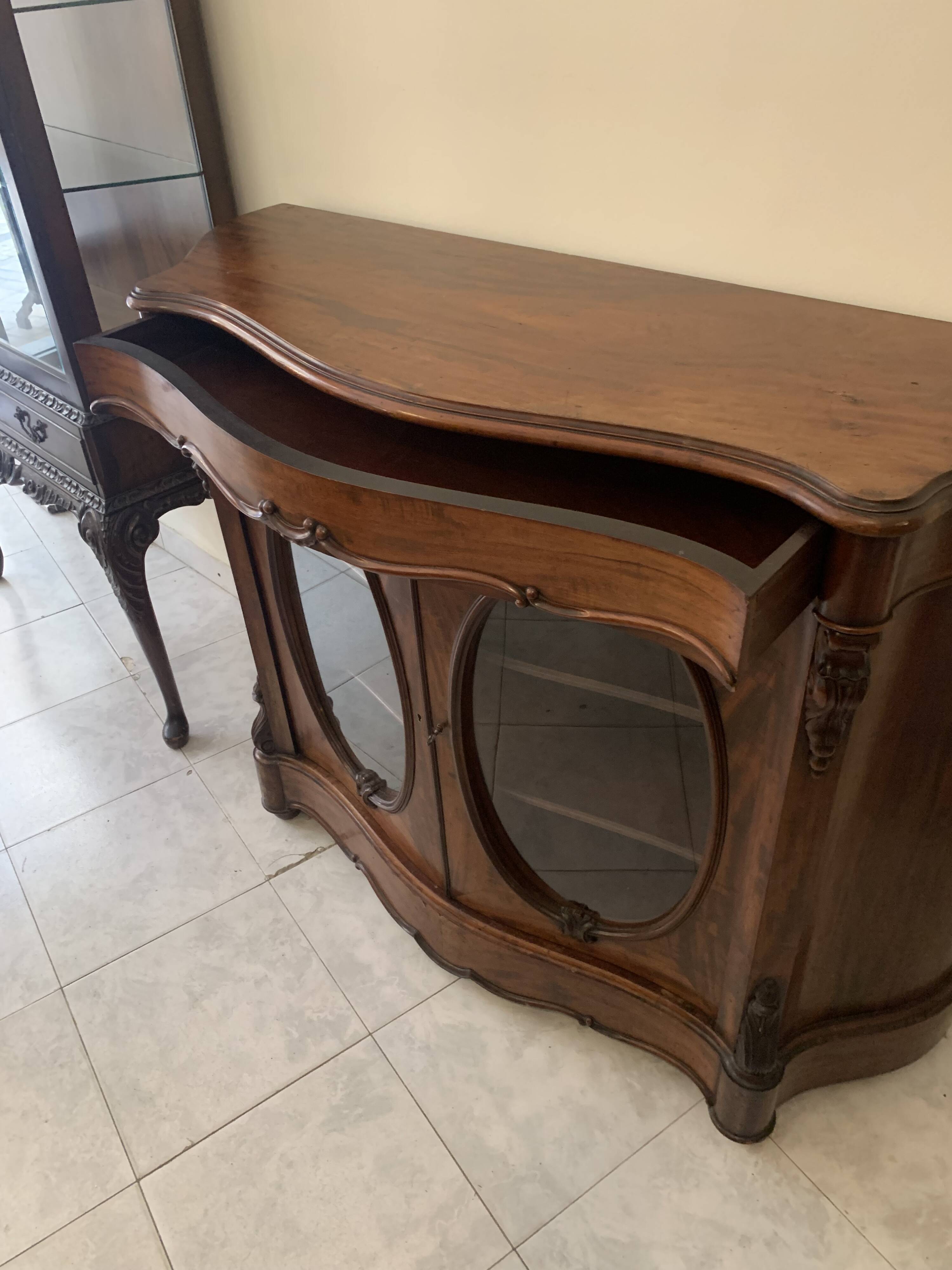 Curved mahogany display cabinet from the Napoleon III period. It has two doors and two shelves.