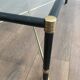 Brass coffee table upholstered in black leather. In the style of Jacques Adnet.