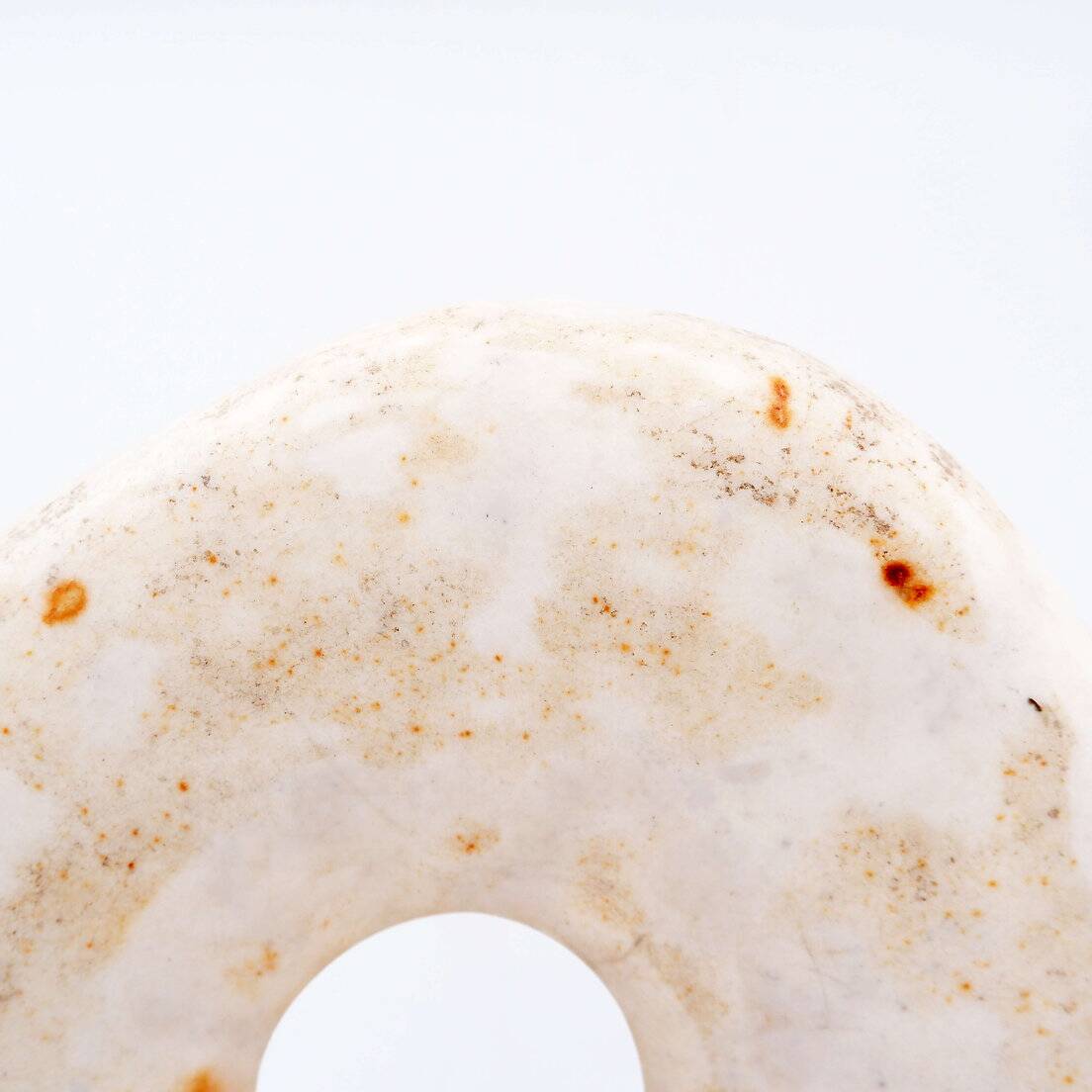 "Wamayuwa" Boiken coin in hand-carved shell mounted on a black metal stand