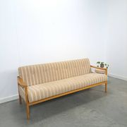 Canapé-lit beige rayé avec cadre en bois