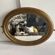 Antique oval mirror in gilded wood, bevelled mercury glass, 19th century.