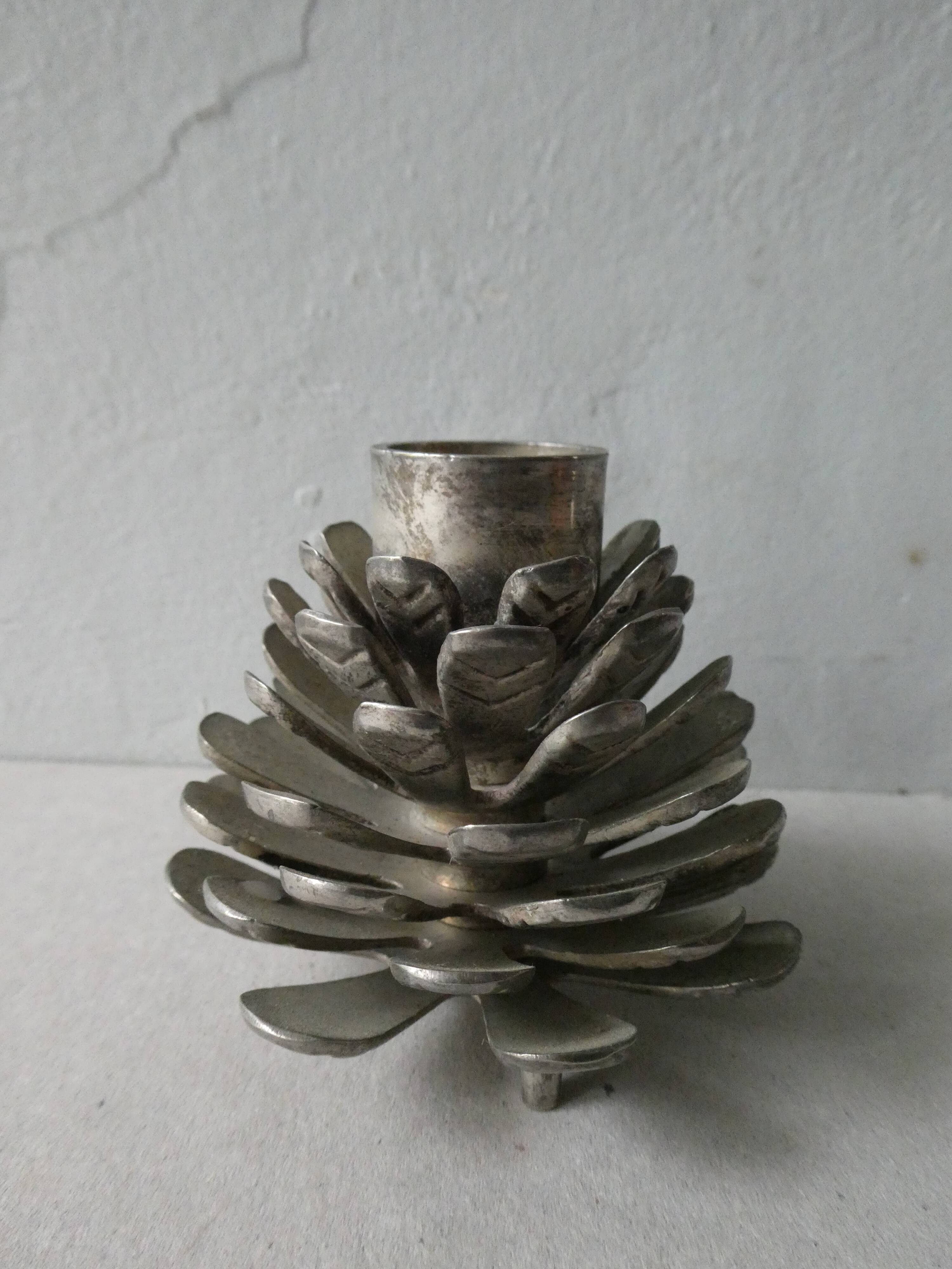Silver-coloured metal pine cone candlestick