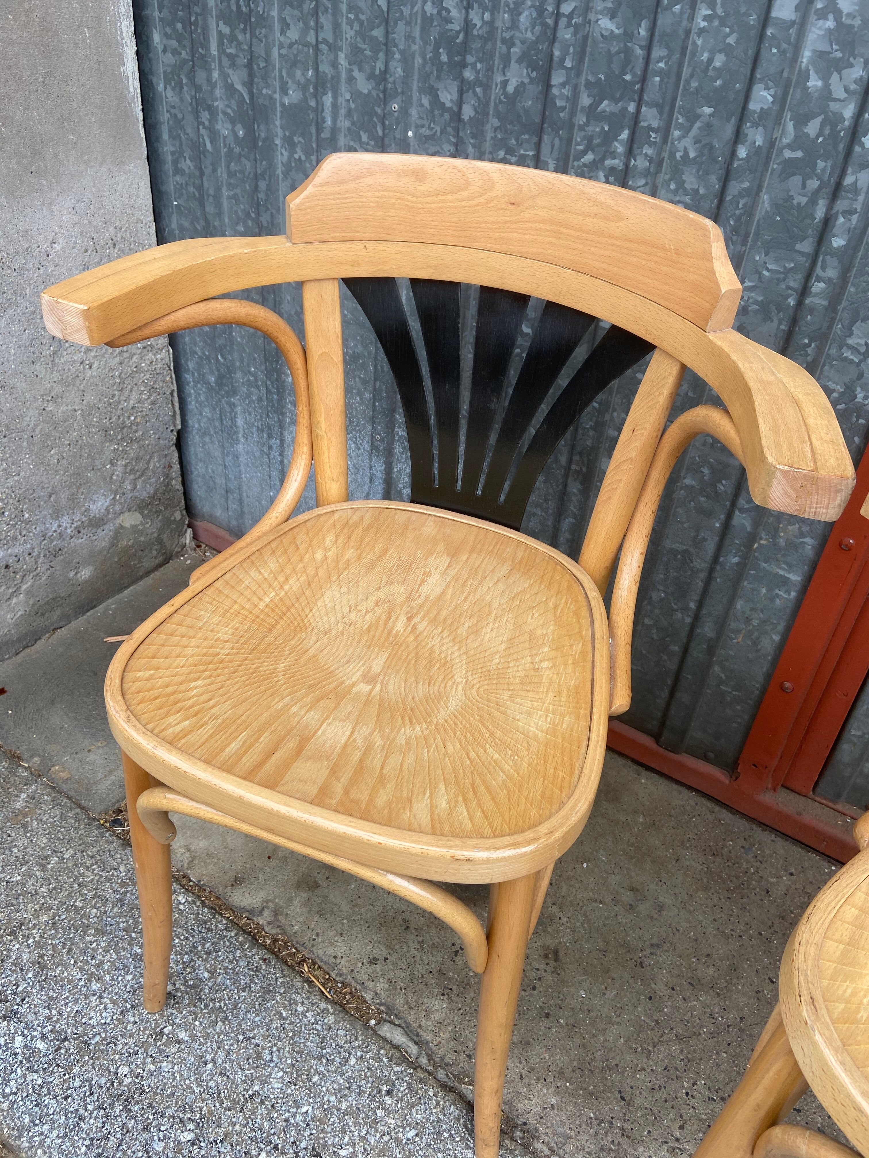 Pair of curved wooden bistro chairs with armrests