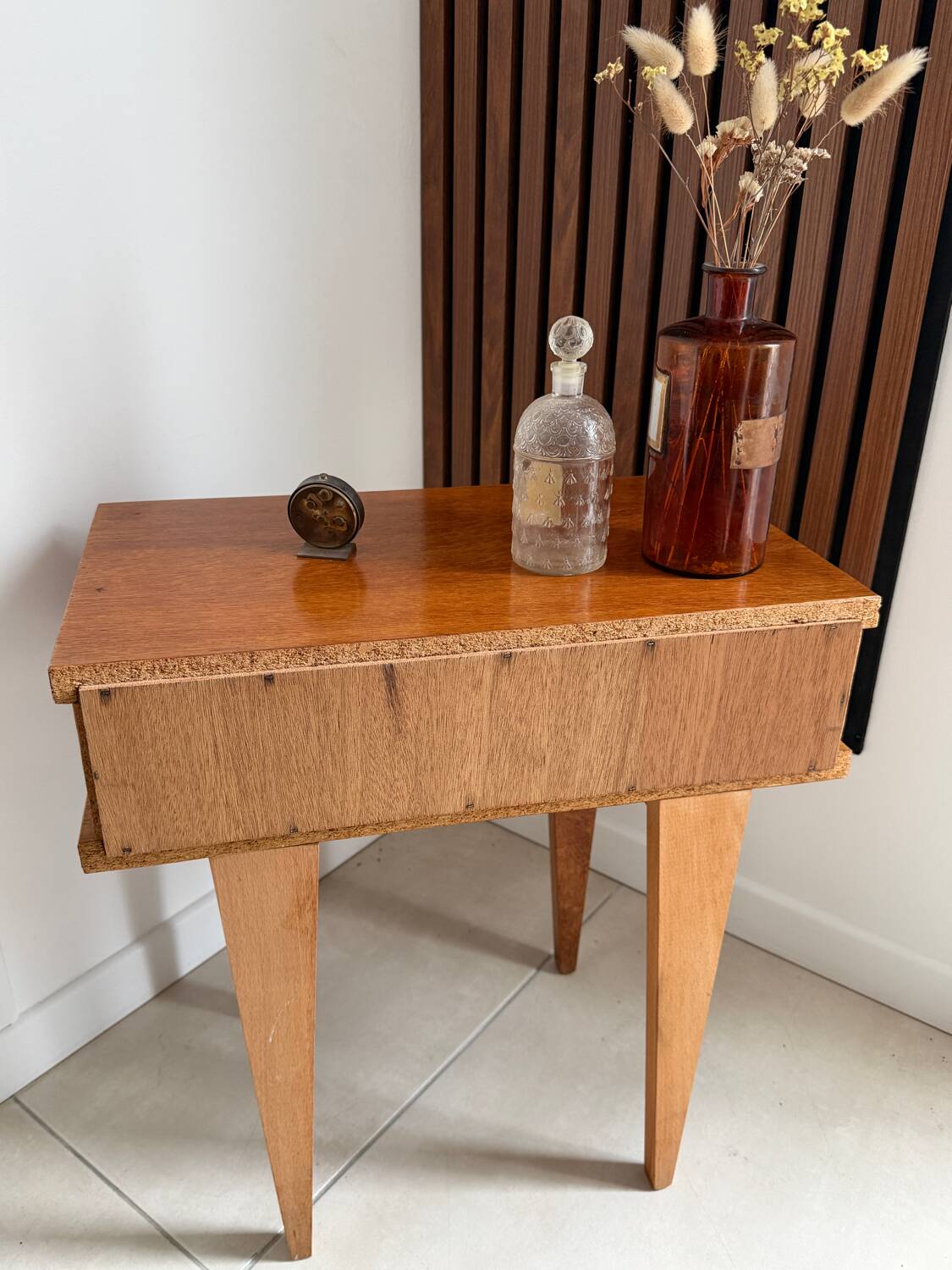 Vintage bedside table with tapered legs.