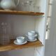 Shallow depth bookcase re-enchanted in pearl gray, wooden shelves.