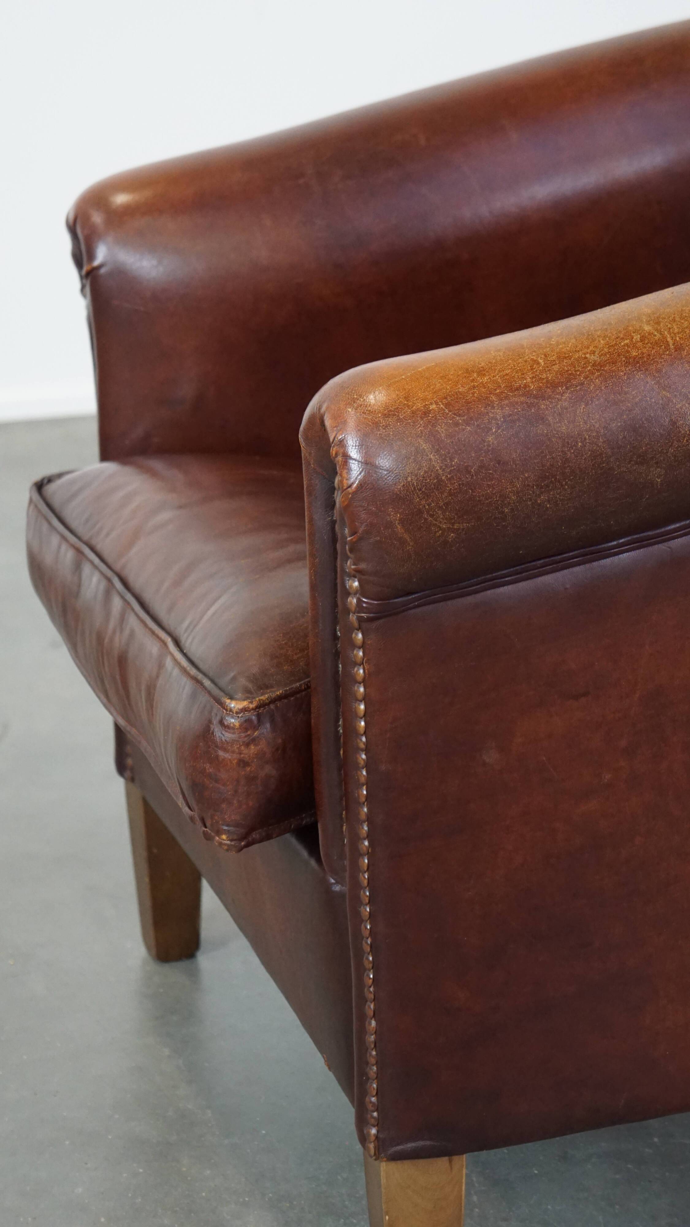 Sheepskin club armchair, correct finishing with decorative nails