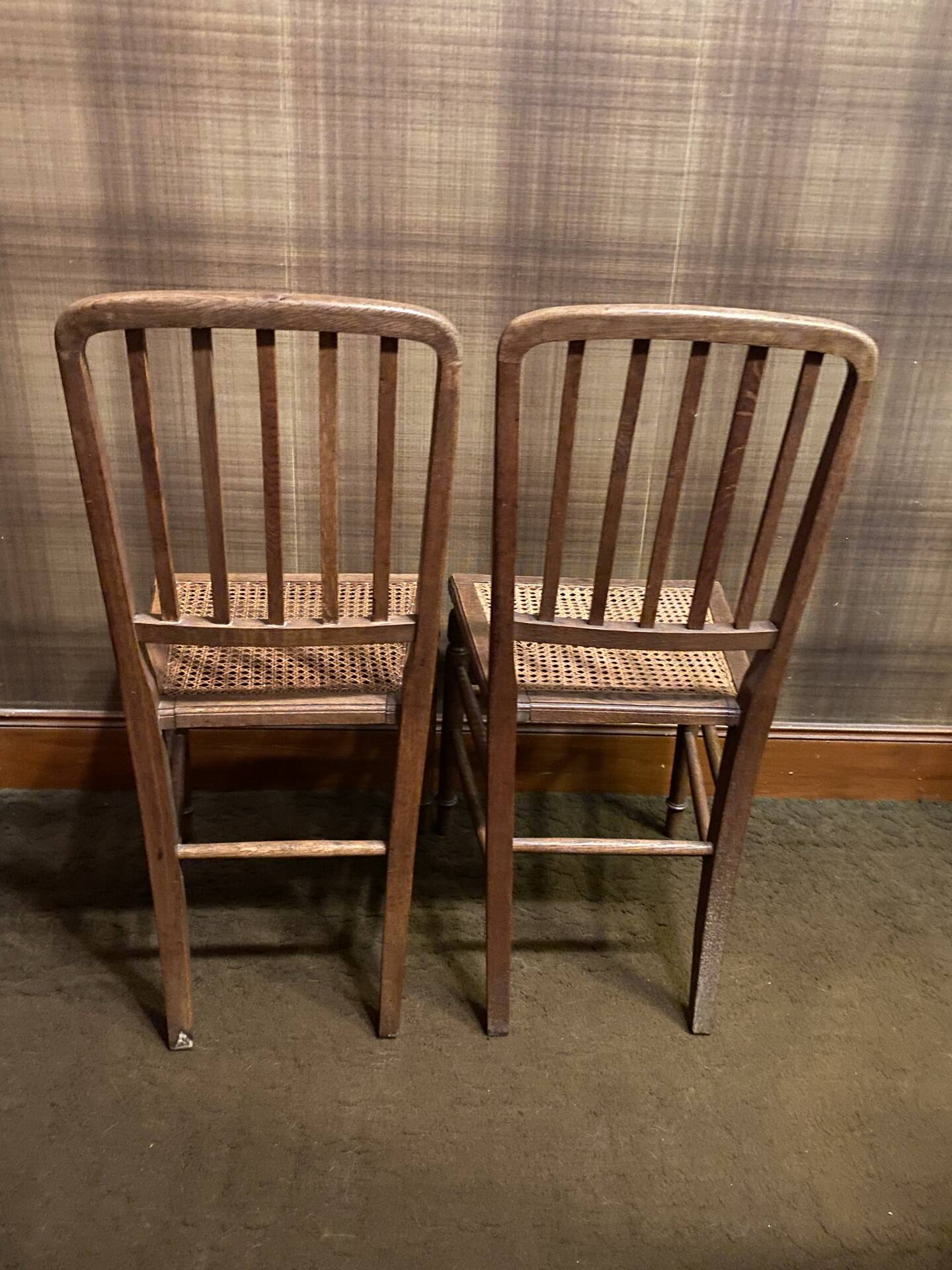 Set of 2 antique wooden chairs with caned seats.