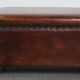 Cognac-colored sheepskin stool with decorative studs