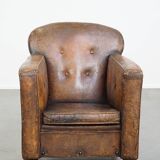 Fauteuil ancien en cuir de mouton sur roulettes et patiné