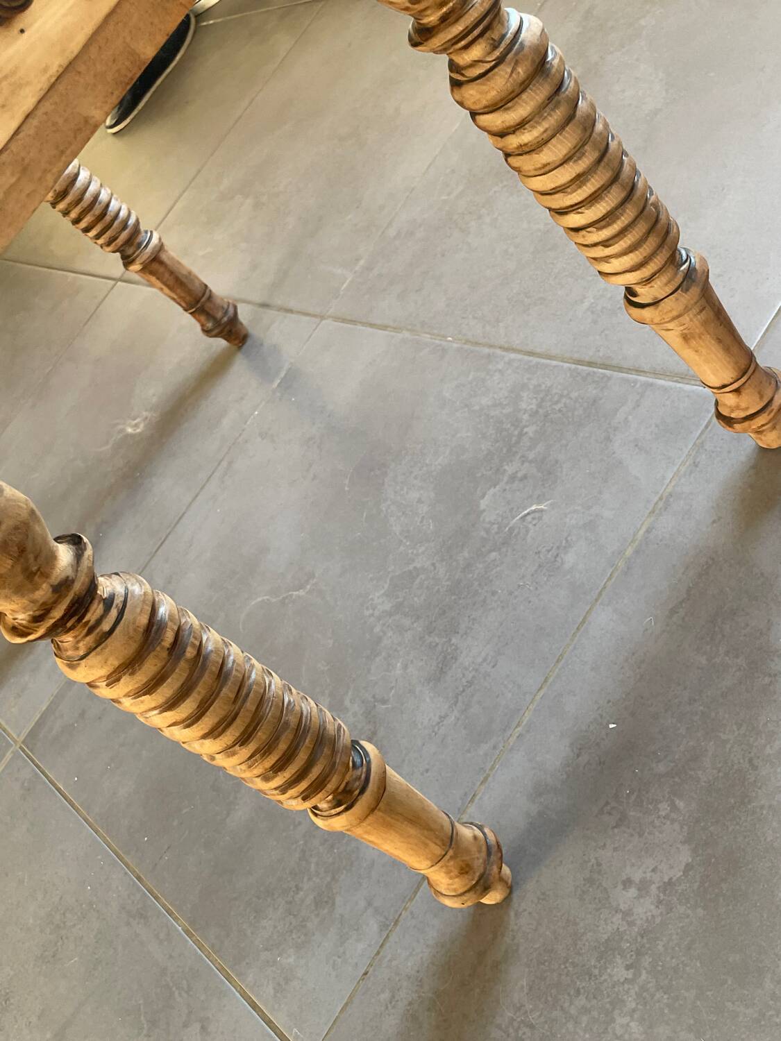 Oval wooden table with drop-leaf edges.