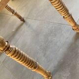 Oval wooden table with drop-leaf edges.