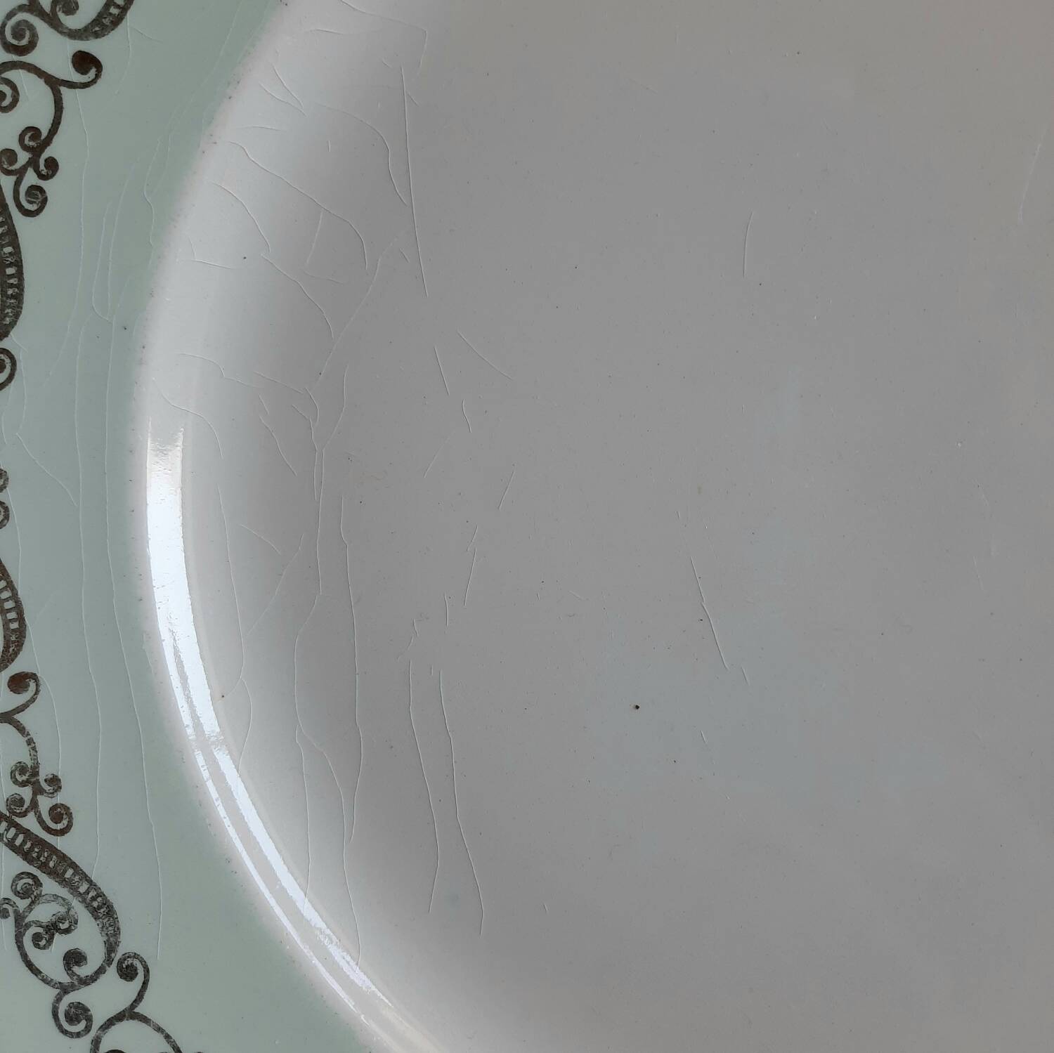 Old mismatched earthenware dinner plates with gold accompanied by a dish