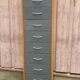 Scandinavian shoe storage cabinet in grey wood and metal.