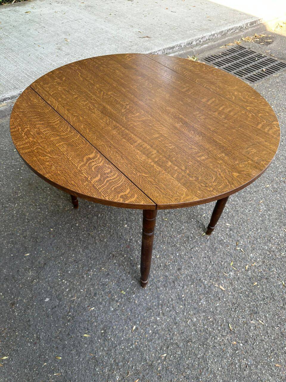 Round kitchen table with extendable leaves in dark wood.