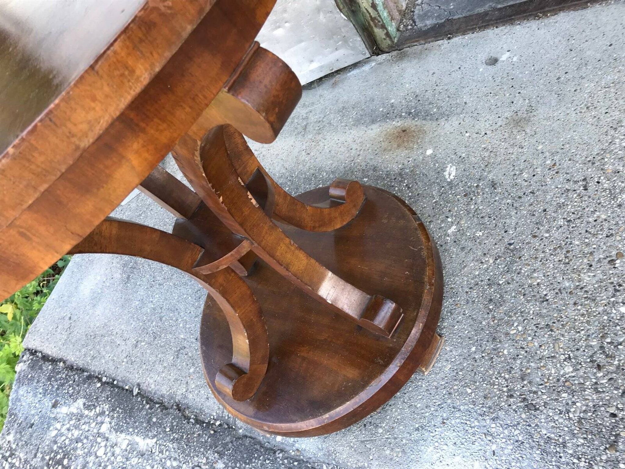 Art Deco side table in brown walnut, round top and scroll legs, France 1930s.