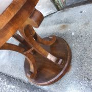 Art Deco side table in brown walnut, round top and scroll legs, France 1930s.