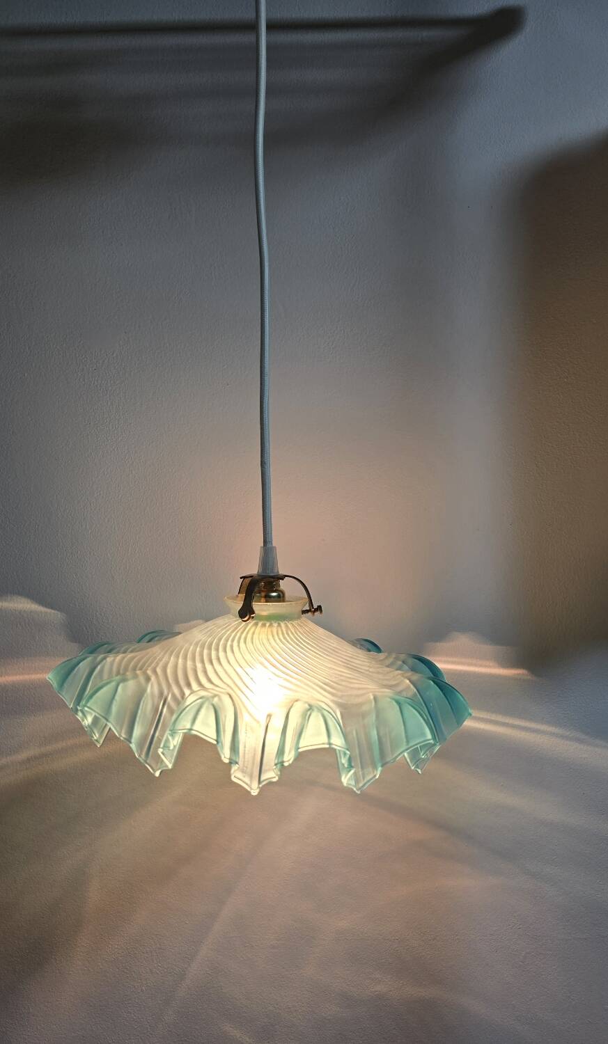 Suspension lampshade with scalloped edges in blue and its interior decoration.