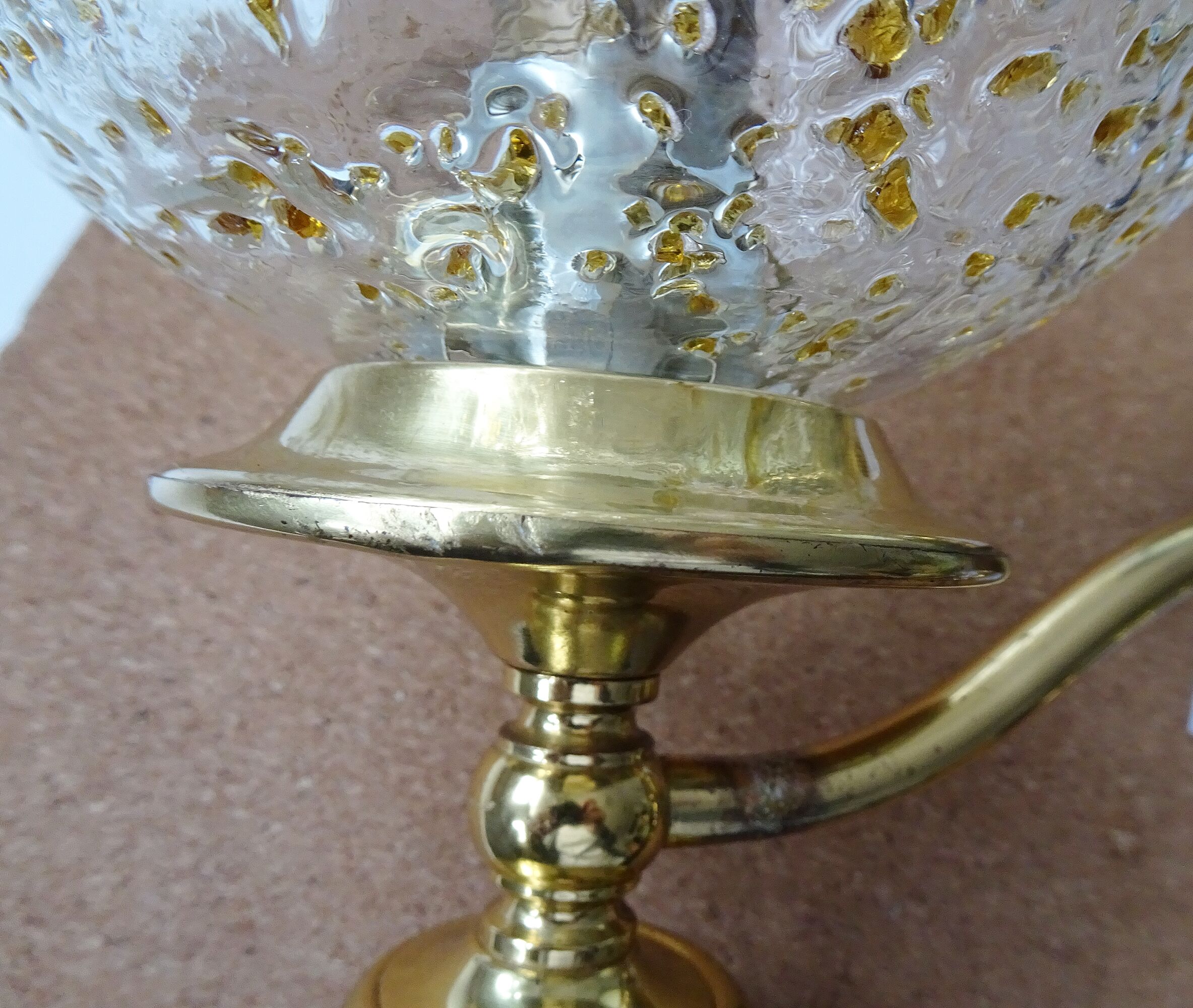 Golden wall lamps with round glass shades and teak veneer