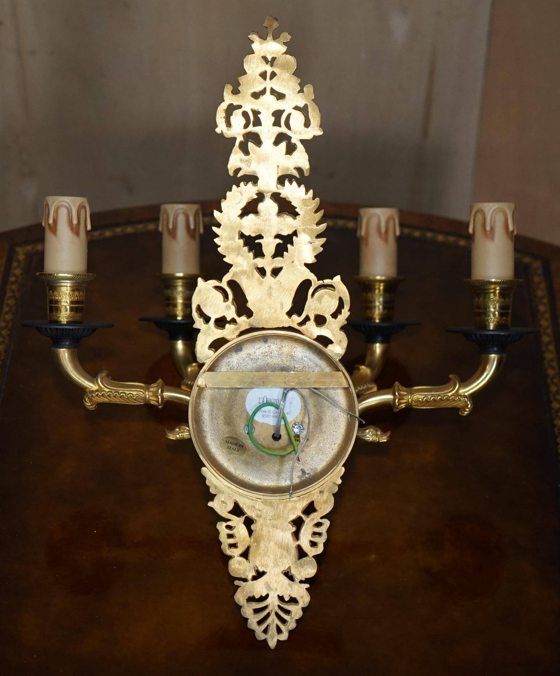 Pair of L'Originale wall sconces plated with 24-carat gold featuring four bronze candles.