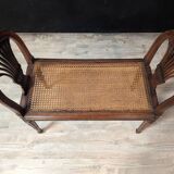 Louis XVI bench in walnut with cane seating.