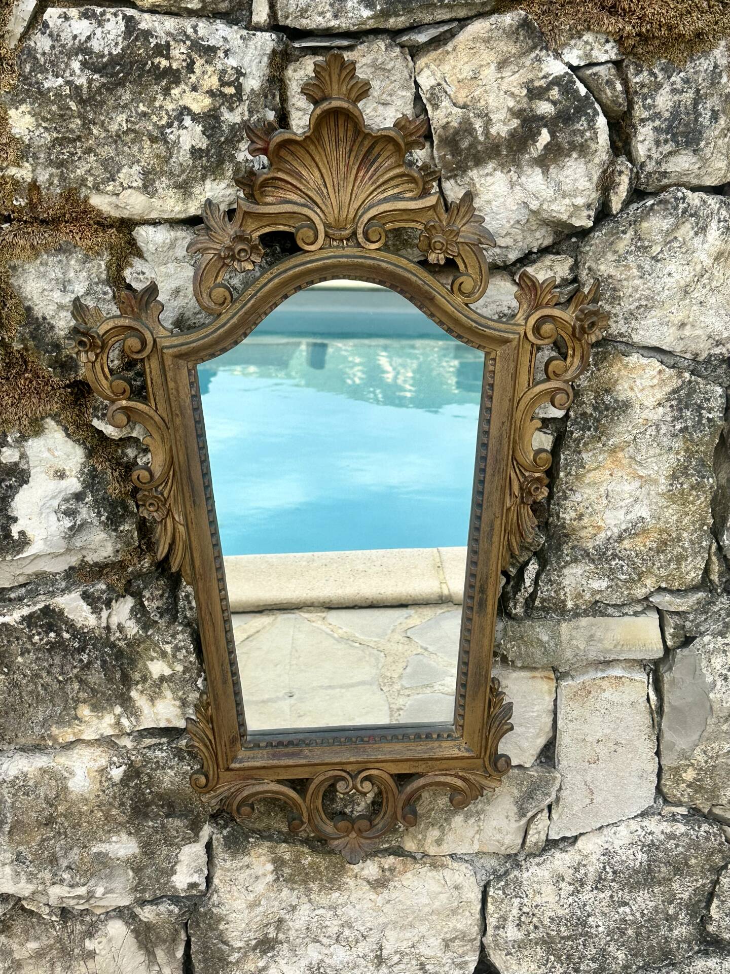 Carved and gilded wooden wall mirror.