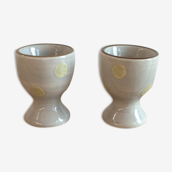 Two beige/greige ceramic egg cups with large yellow polka dots